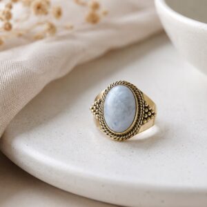 Bague en laiton pierre de lune modèle Lolïa posée sur une coupelle blanche.